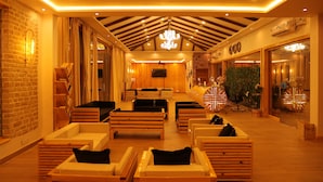 Un vestíbulo de hotel con muebles de madera, un candelabro y un ventilador de techo.