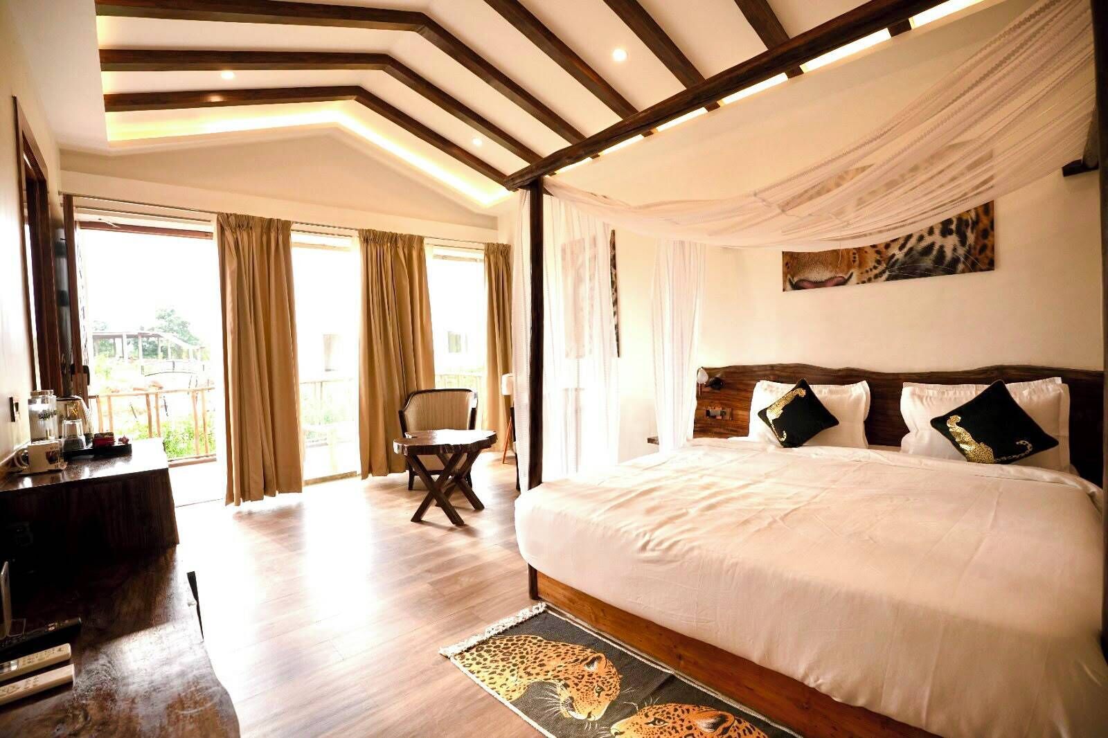 A spacious bedroom with a large bed, a chair, and a view of the outdoors.