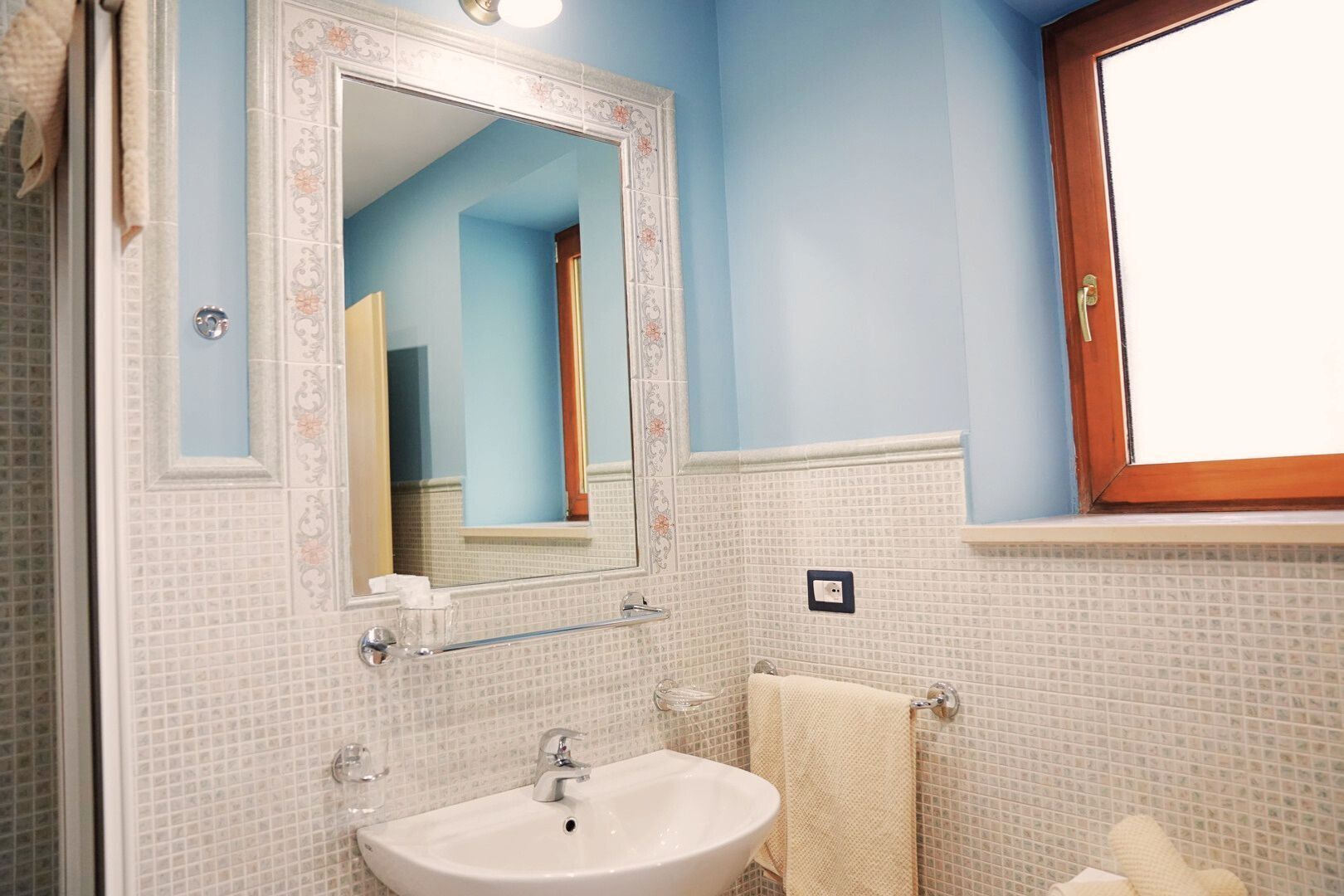 A bathroom with a sink, mirror, and towel rack.