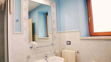 A bathroom with a sink, mirror, and towel rack.