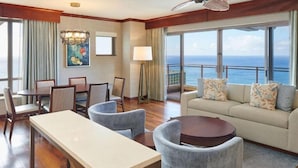 A room with a dining table, chairs, a sofa, a lamp, and a view of the ocean. - Cozy 1-bedroom apartment in marvelous Honolulu with AC and gym Grand Waikikian (Honolulu)