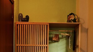 Une armoire en bois à claire-voie, dotée d’une tringle pour suspendre les vêtements et d’une étagère.