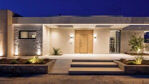 Een modern huis met een houten deur, een klein raam en een goed verlichte ingang.