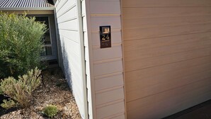 Ett hus med en garageport, en brevlåda och en liten buske.
