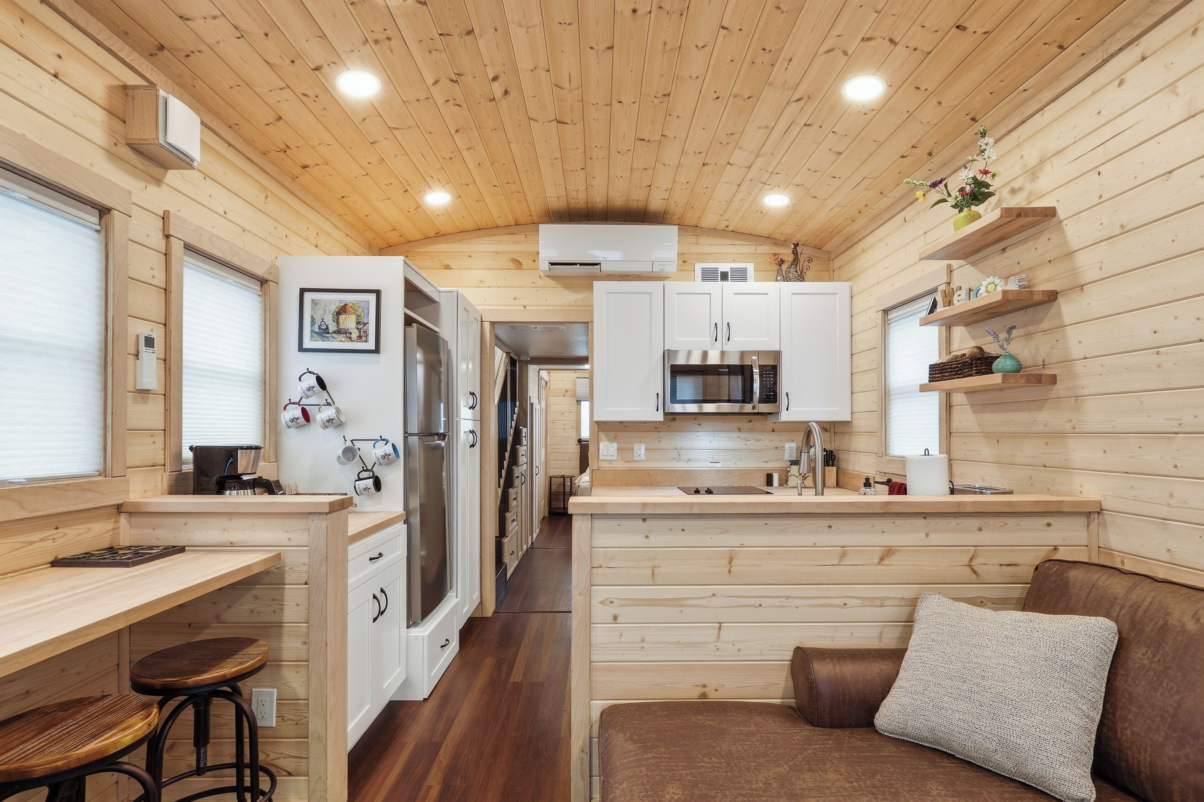A compact kitchen with white cabinets, a microwave, and a stove.