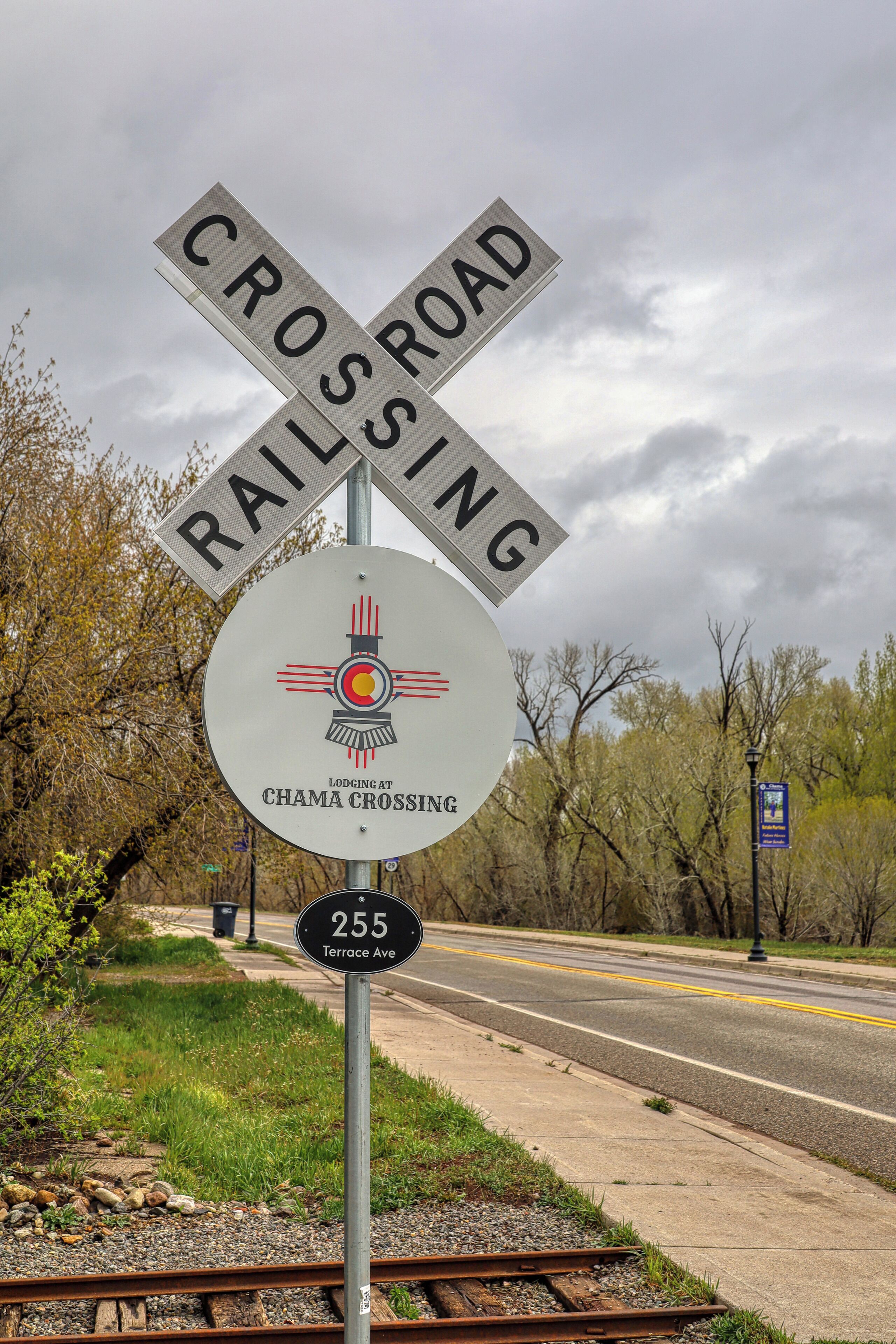 A railroad crossing sign with a logo for Chama Crossing.