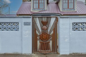 A building with a metal gate, a number '257' on the wall, and a decorative metal design above the gate. - Chama Crossing - Historic Home next to Railroad (Chama)