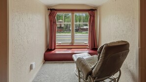 A room with a window, a bench, and a chair. - Chama Crossing - Historic Home next to Railroad (Chama)