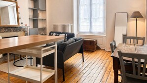 A modern apartment with a dining area, sofa, and a large window. - Cosy & Welcoming Apartment – City Center – Sleeps 3/4 (Angers)