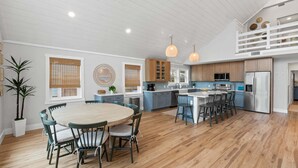 A spacious kitchen with a central island, wooden cabinets, and pendant lighting. - Fall Deals + Snowbird Rates | Coastal Stay Near the Beach (Panama City Beach)