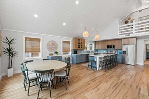 A spacious kitchen with a central island, wooden cabinets, and pendant lighting. - Fall Deals + Snowbird Rates | Coastal Stay Near the Beach (Panama City Beach)