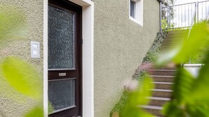 Ein Haus mit strukturierter Fassade, einer dunklen Tür und einem kleinen Fenster.