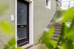 Ein Haus mit strukturierter Fassade, einer dunklen Tür und einem kleinen Fenster.