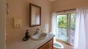 Une salle de bain avec un lavabo, un miroir et des toilettes.