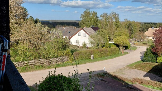 A residential area with houses, a paved road, and a clear sky. - Vacation apartment with a view (Joachimsthal)