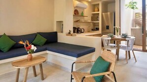 Uma sala de estar moderna com um sofá, uma mesa de jantar e uma cadeira.
