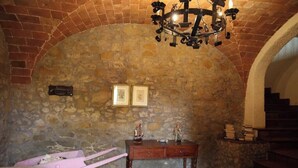 A stone-walled room with a wooden table, a pink hammock, and a chandelier. - Casa Teo:  Relaxation and Culture  in the Heart of Tuscany (Toscana)