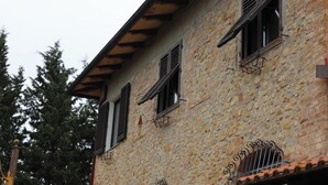 A stone building with multiple windows and a metal balcony railing. - Casa Teo:  Relaxation and Culture  in the Heart of Tuscany (Toscana)