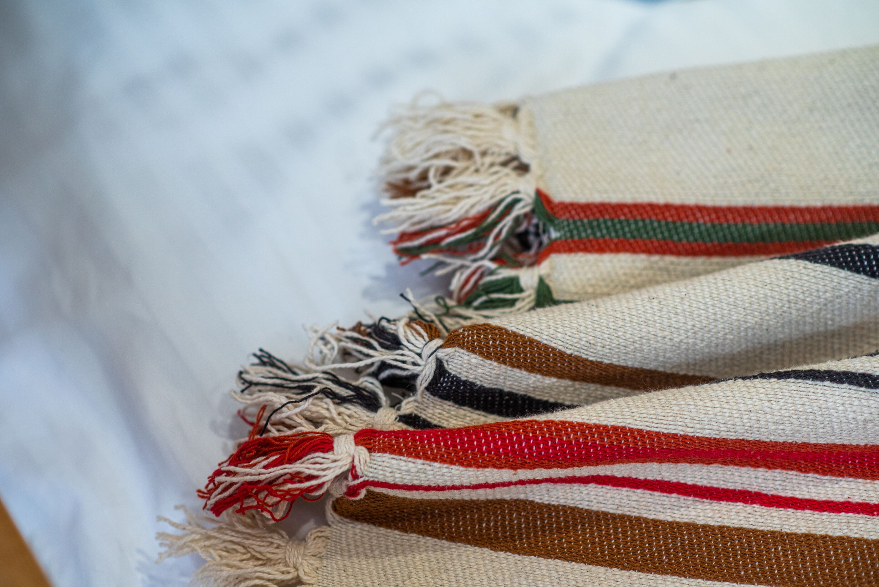 A close-up of a striped fabric with fringes.