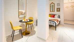 Una habitación moderna con una cama, una mesa redonda y dos sillas.