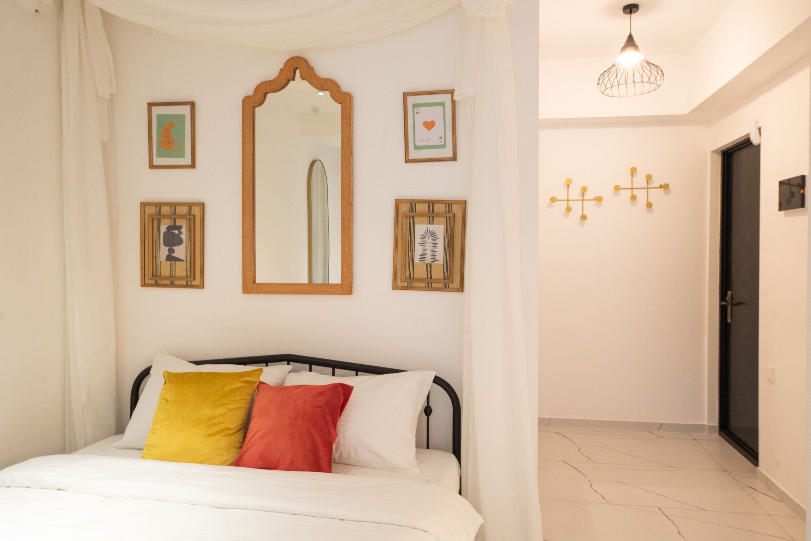 Un dormitorio con cama, espejo y adornos en la pared.