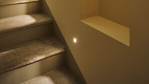 A staircase with carpeted steps and recessed lighting. - Ariosto Living (Milan)