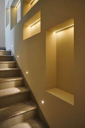 A staircase with carpeted steps and recessed lighting.