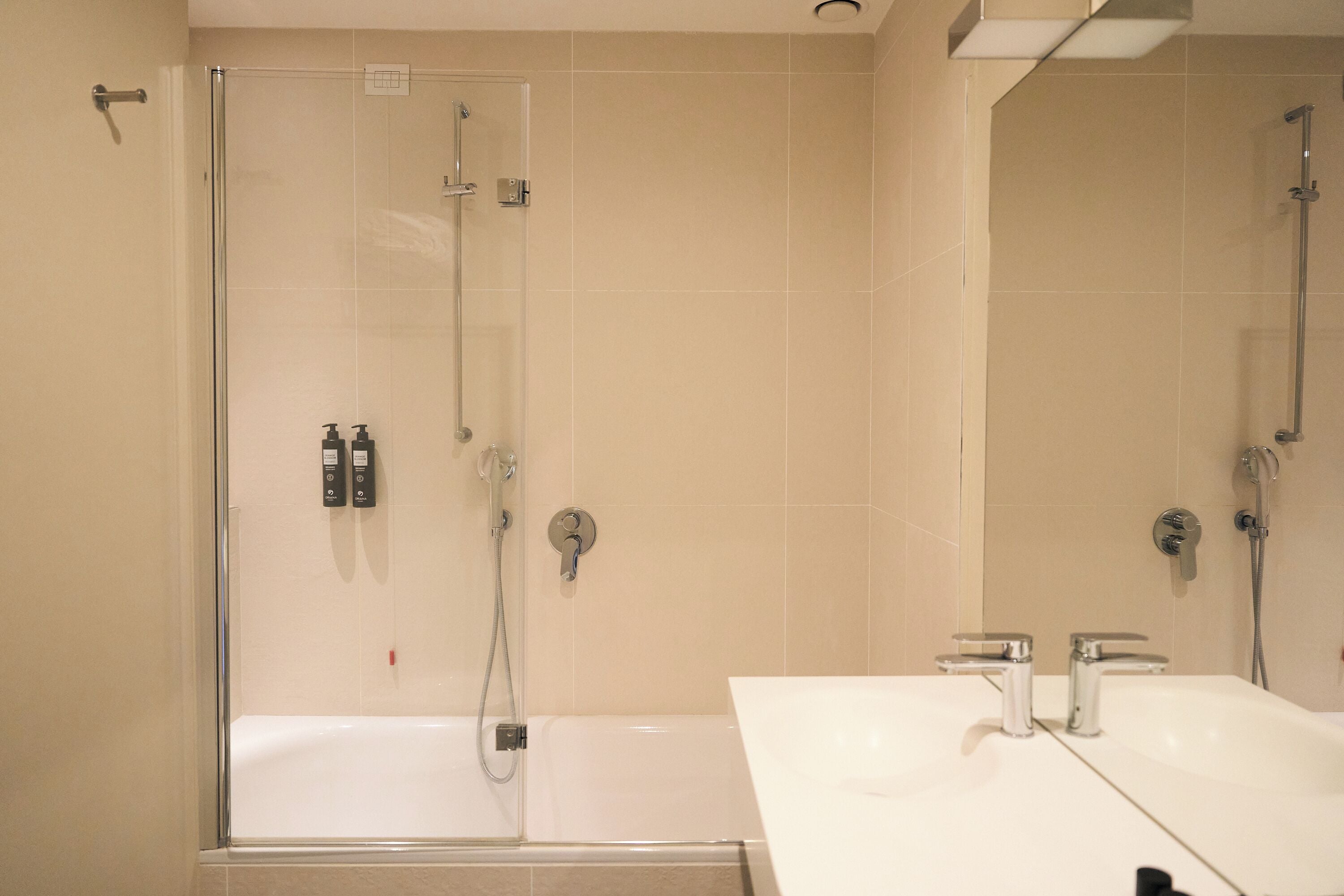 Ein Badezimmer mit Duschkabine, Badewanne und einem Doppelwaschbecken mit Spiegel.