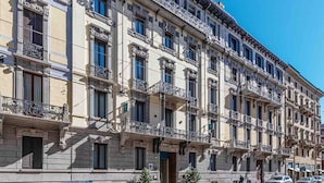 A multi-story building with ornate balconies, large windows, and a classic architectural style. - Ariosto Living (Milan)