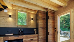 Eine moderne Küche mit Holzschränken, einem eingebauten Ofen und einem großen Fenster.