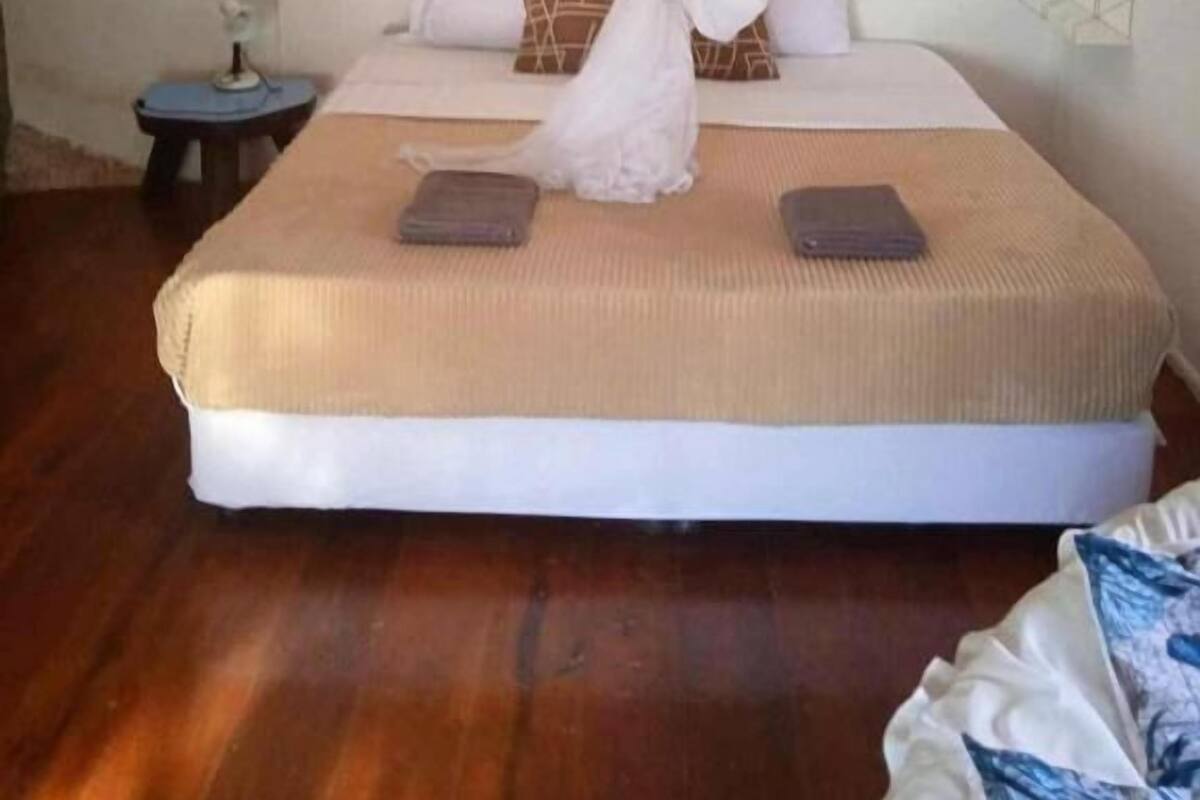 Ein Schlafzimmer mit einem Bett, Nachttischen und einem Baldachin.