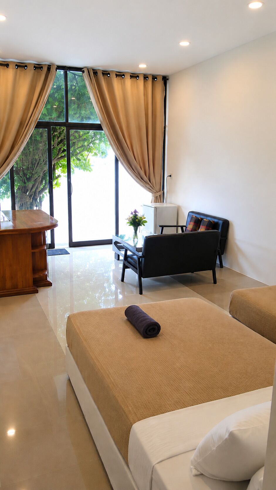 Habitación de hotel moderna con cama, escritorio, una silla y vista a zonas verdes.