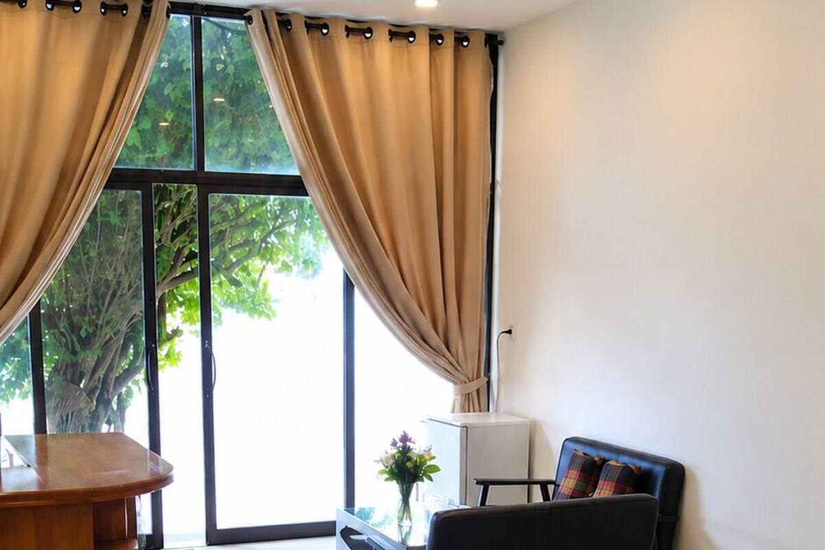 Ein modernes Hotelzimmer mit Bett, Schreibtisch, Stuhl und Blick auf Grün.