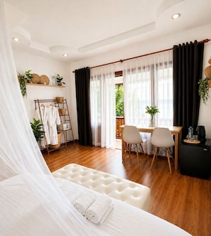 A hotel room with a bed, a dining area, a desk, and a view of the outdoors. - Secret Place Hotel and Restaurant (Haad Yao)