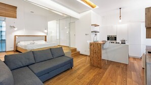 Eine moderne Wohnung mit Schlafzimmer, Wohnbereich und Küche.