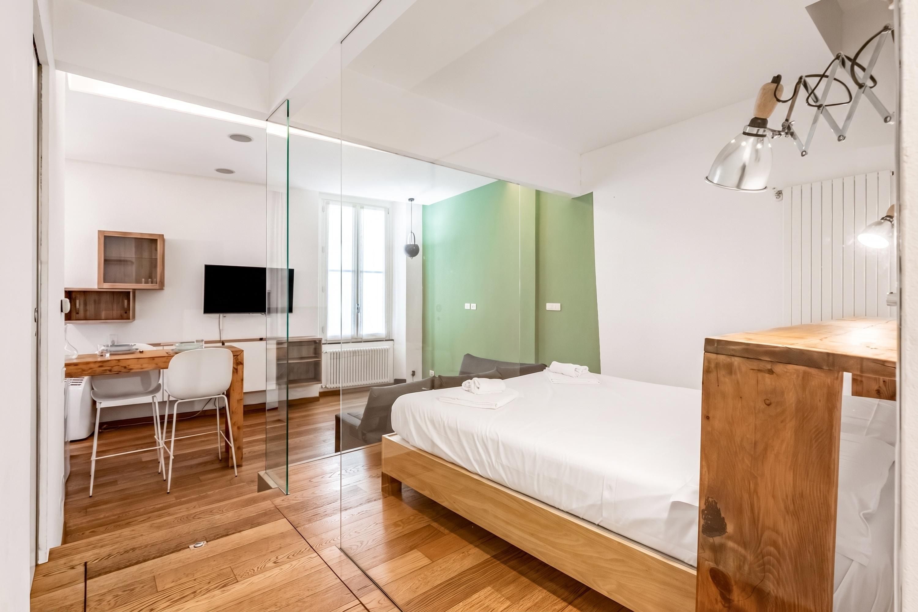 Une chambre à coucher moderne avec un lit en bois, un bureau et une chaise.