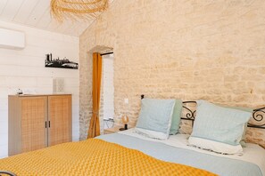 Une chambre à coucher comprenant un lit, une armoire, un climatiseur fixé au mur et un élément décoratif sur le mur.
