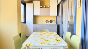 Una cucina compatta con mobili bianchi, un lavello e una finestra.