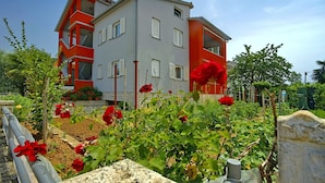 Ein zweistöckiges Gebäude mit modernem architektonischen Design, mit Balkonen und großen Fenstern.