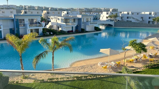 A resort with a swimming pool, beach area, and modern white buildings. - Fouka North Coast CL3-CH19-02 (Marsa Matrouh)