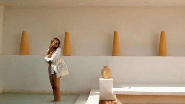 A room with a white wall, a white bench, and a vase on a pedestal. - Loft Boutique *Starlink | Private Pool * La Punta (La Barra de Colotepec)