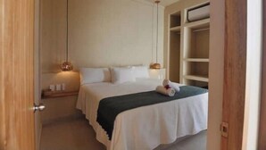 A bedroom with a bed, bedside lamps, a nightstand, and a wardrobe. - Loft Boutique *Starlink | Private Pool * La Punta (La Barra de Colotepec)