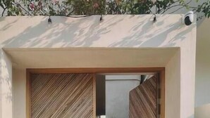 A modern entrance with wooden slatted doors and a potted plant on the right. - Loft Boutique *Starlink | Private Pool * La Punta (La Barra de Colotepec)
