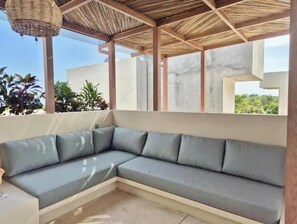 A covered outdoor seating area with a sectional sofa, a woven basket overhead, and a view of greenery. - Loft Boutique *Starlink | Private Pool * La Punta (La Barra de Colotepec)
