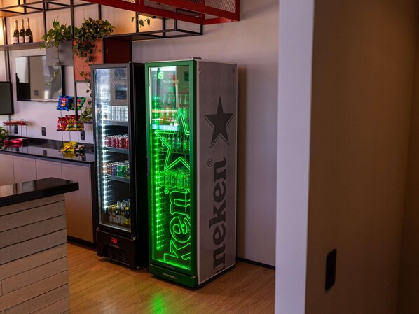 A modern kitchen with a refrigerator and a vending machine.