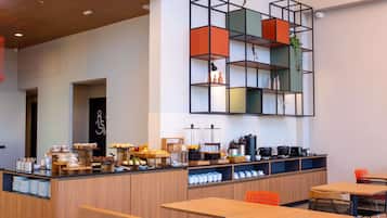 Um café moderno com mobiliário de madeira, um balcão com diversos produtos alimentícios e uma estante geométrica peculiar.