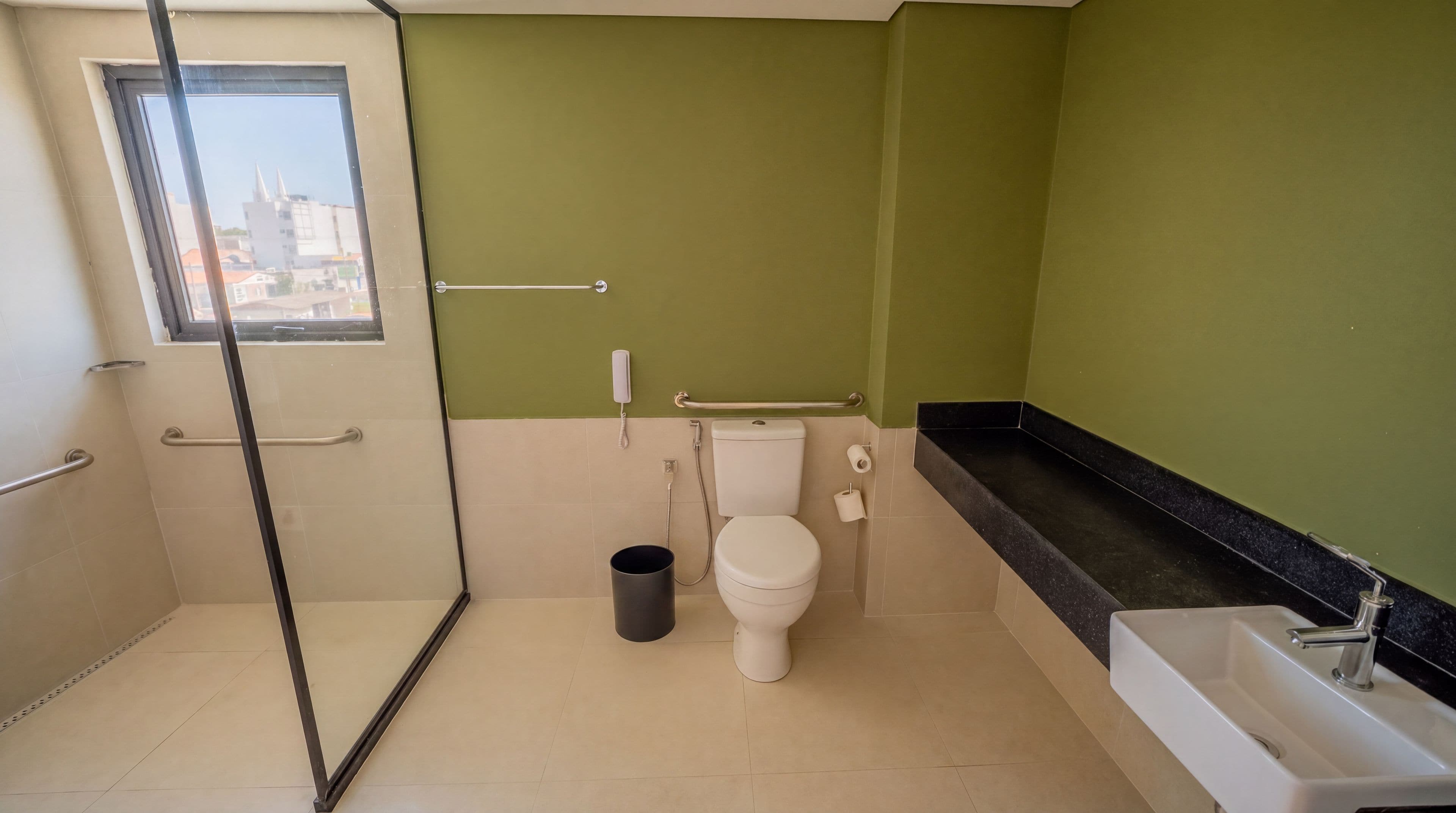 Un baño con inodoro, ducha, lavabo y cubo de basura.