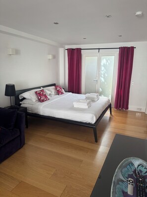 Ein modernes Hotelzimmer mit Bett, Schreibtisch und Blick ins Freie.