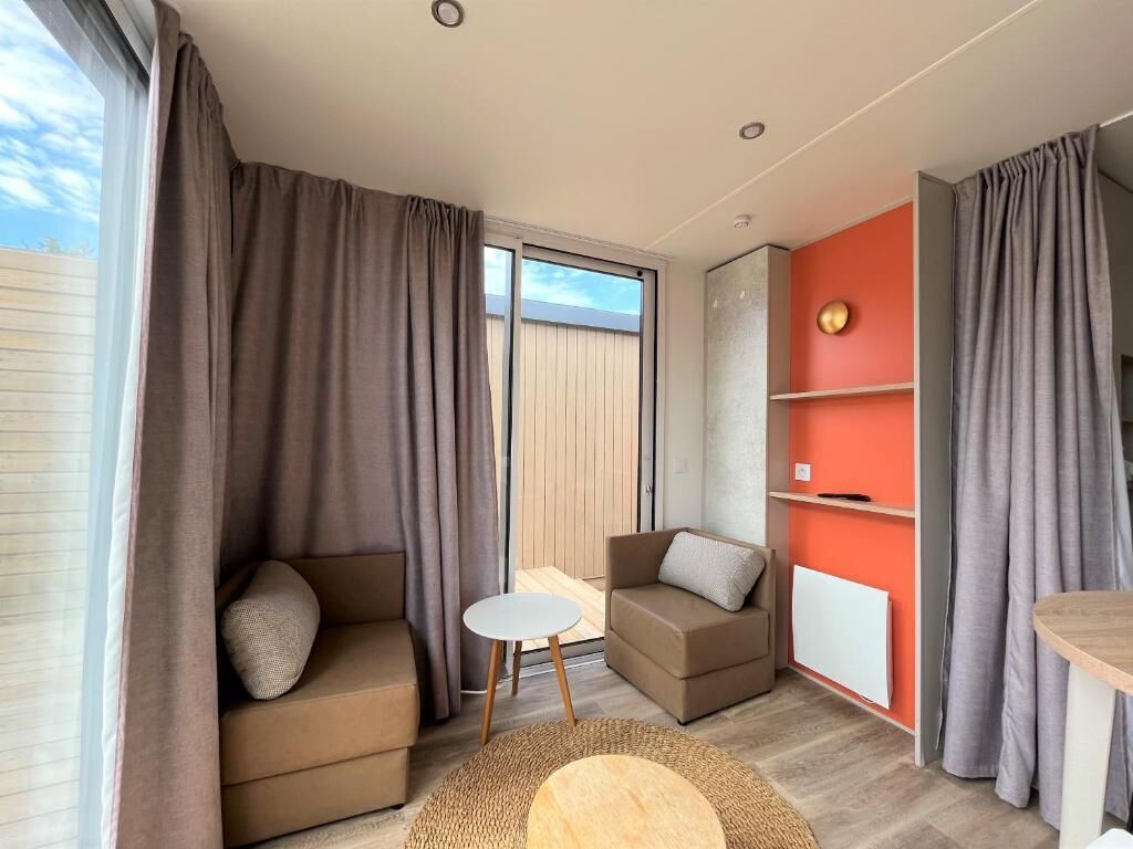 A modern living room with a sofa, a small table, and a red accent wall.