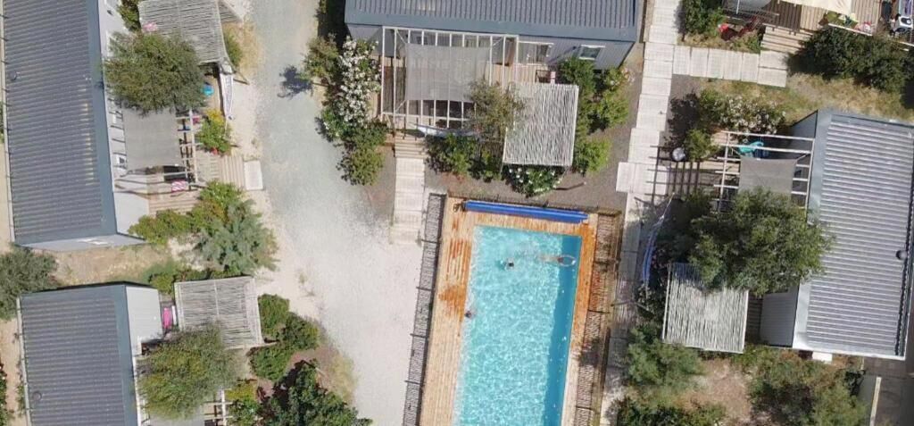 Vista aérea de una zona residencial con piscina rodeada de casas.